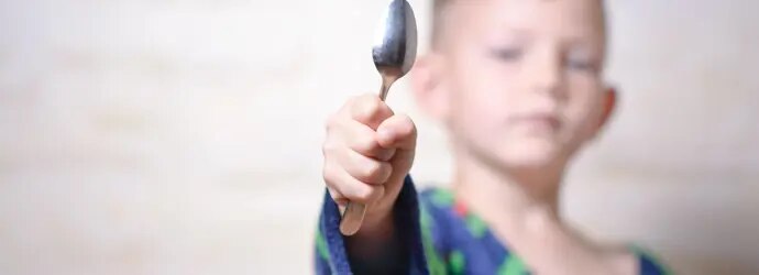 Nuori poika lusikka kädessä valmiina hopean puhdistukseen.