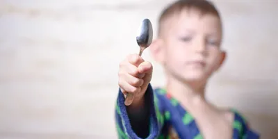 Nuori poika lusikka kädessä valmiina hopean puhdistukseen.