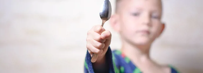 Nuori poika lusikka kädessä valmiina hopean puhdistukseen.