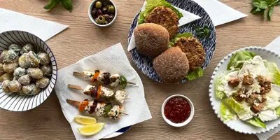 Nuori perhe nauttii grillauksesta puutarhassa aurinkoisena päivänä