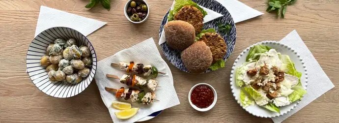 Nuori perhe nauttii grillauksesta puutarhassa aurinkoisena päivänä