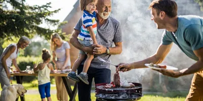 Mies valmistelee grillijuhlia perheen takapihalla