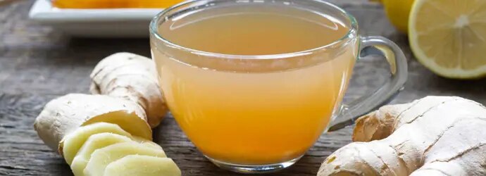 Zoom sur une tasse de thé avec du citron et du gingembre ; un très bon remède naturel pour le rhume.  