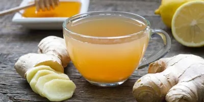 Zoom sur une tasse de thé avec du citron et du gingembre ; un très bon remède naturel pour le rhume.