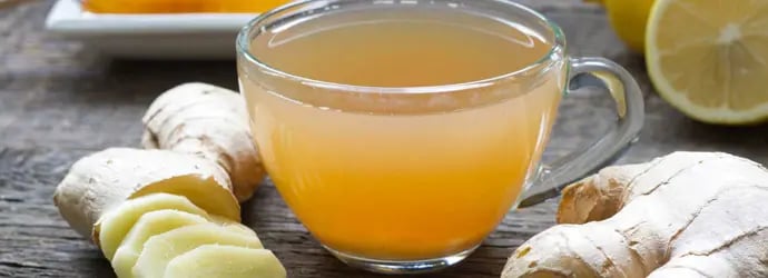 Zoom sur une tasse de thé avec du citron et du gingembre ; un très bon remède naturel pour le rhume.