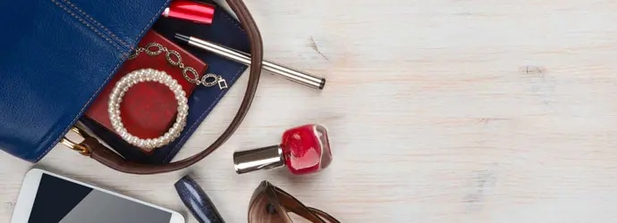 Le sac d'une femme sur un bureau en bois avec son contenu qui déborde