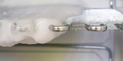Sulatetun pakastimen hyllyjä puhdistetaan