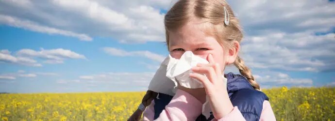 Une jeune fille se mouche dans un champ et souffre peut-être l'allergie au pollen