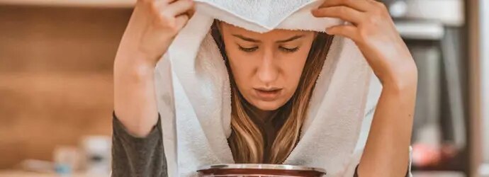 Une femme effectue un traitement naturel contre la sinusite : l’inhalation de vapeur d’eau chaude. 