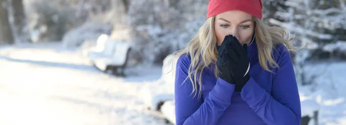 Une jeune femme court dans la neige avec un rhume et veut savoir comment traiter une allergie au pollen avec un remède maison
