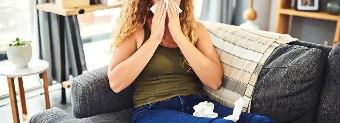 Une femme avec des symptômes de rhume des foins se mouche le nez