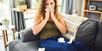 Une femme avec des symptômes de rhume des foins se mouche le nez
