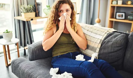 Une femme avec des symptômes de rhume des foins se mouche le nez