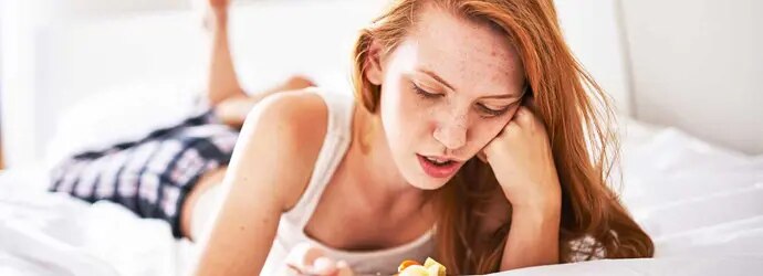 Femme au lit avec un bol de soupe ne veut pas manger