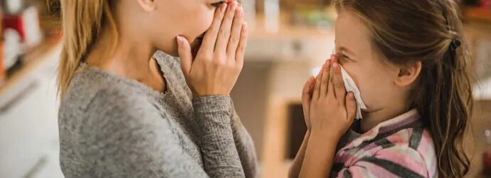Äiti näyttää tyttärelleen, kuinka nenäverenvuoto pysäytetään