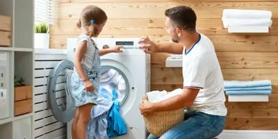 Père et fille font la lessive ensemble et passent un moment amusant
