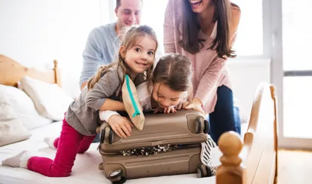 Parents et leurs deux filles faisant une valise