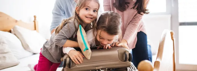 Parents et leurs deux filles faisant une valise