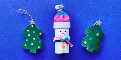 Idées de déco de Noël avec des rouleaux de papier toilette : un bonhomme de neige et deux sapins de Noël.  