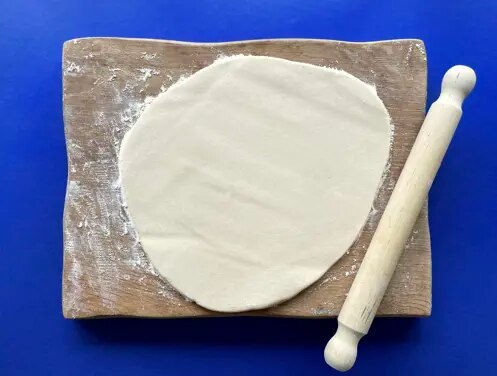 Enfants riant dans des chapeaux de chef cuisant et faisant un gâchis dans la cuisine