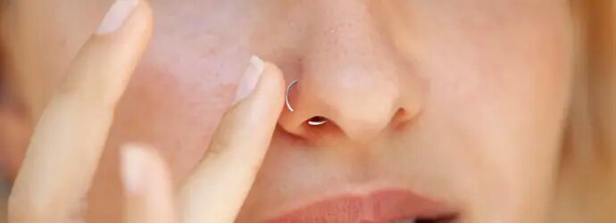 Femme touchant son piercing au nez